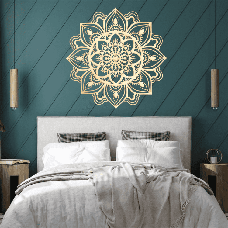 Decorative mandala wall art on a teal wall above a bed with white bedding.