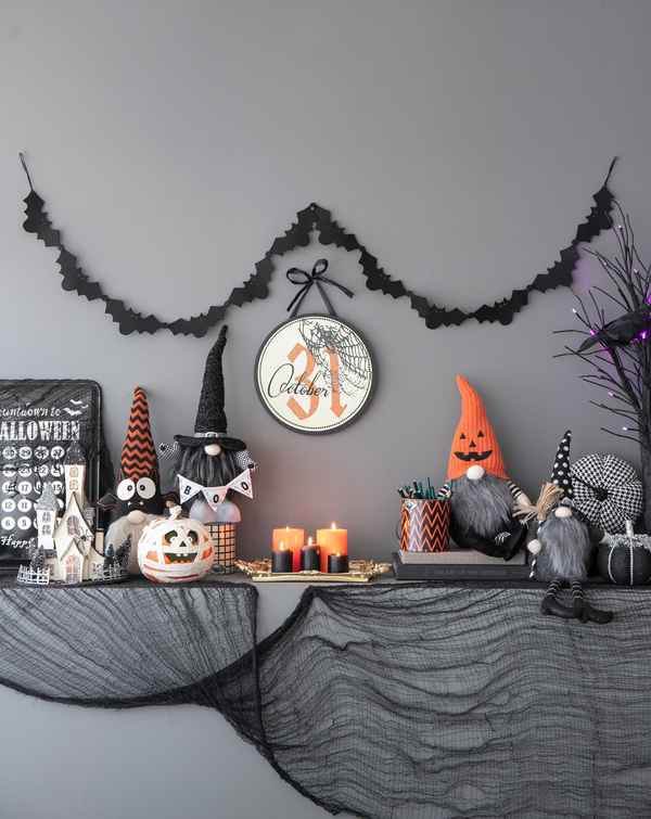 Halloween circle sign set of 2 with October 31 date, black and orange accents, hanging on gray wall with black garland for holiday decor
