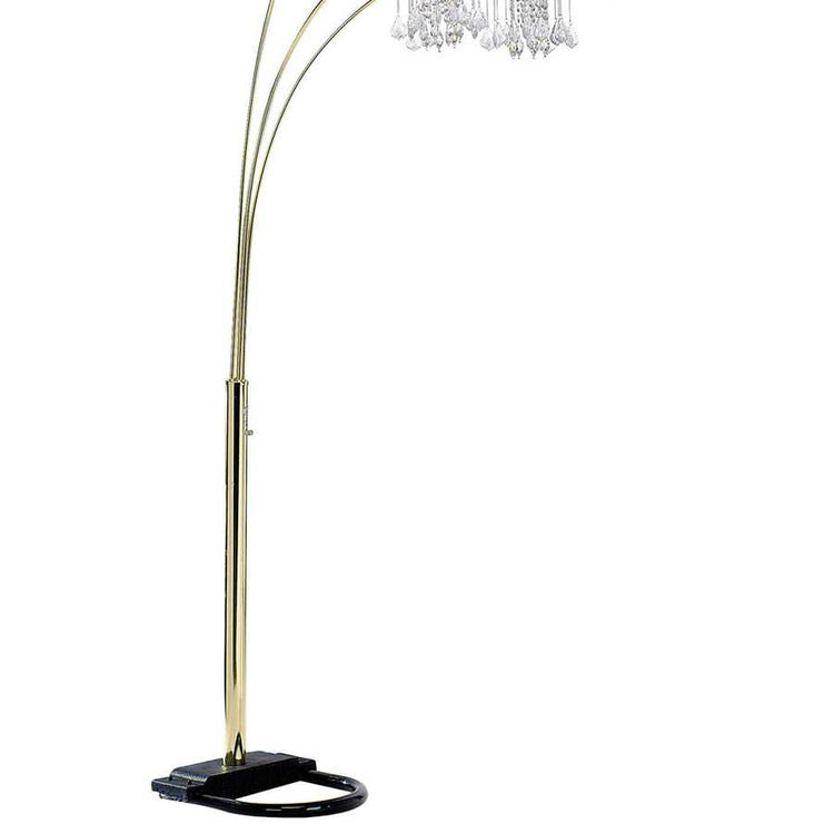 Arc floor lamp with gold base and crystal-like top on a white background