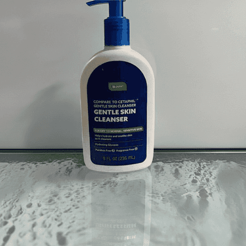 Bottle of gentle skin cleanser on a reflective surface with a neutral background
