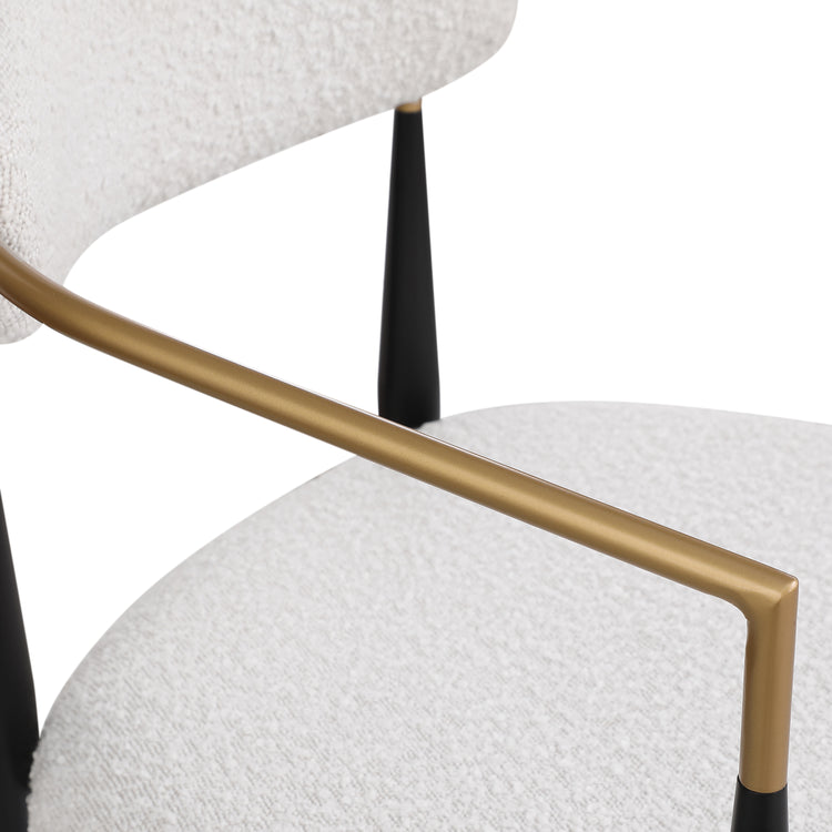 Close-up of a chair with a gold armrest and white cushioned seat on a white background