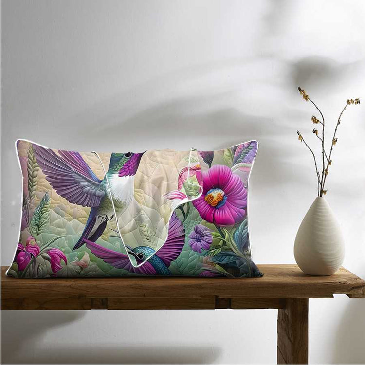 Decorative pillow with floral and bird design on a wooden bench with a vase.