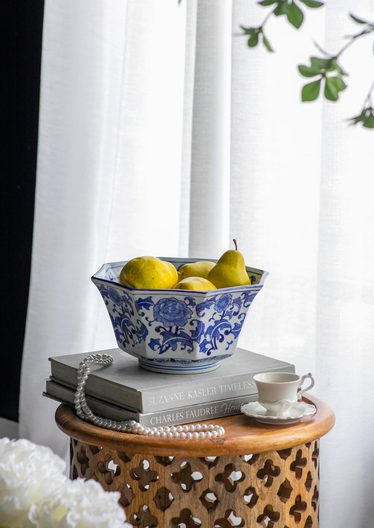 Blue and White Decorative Bowl - Porcelain, Elegant Design filled with pears, styled on books beside a teacup and white curtain.