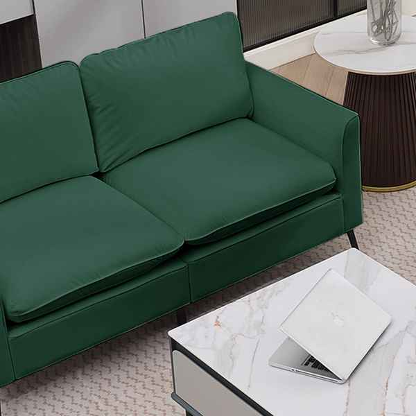Green sofa in a living room setting with a laptop on a coffee table.