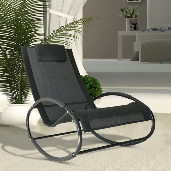 Modern black mesh garden rocking chair indoors near potted plant and white curtains