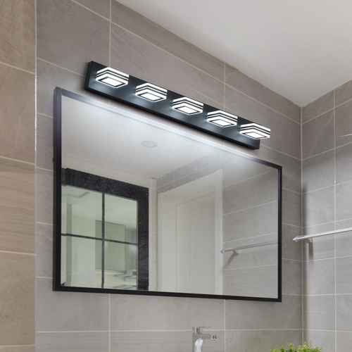 A modern bathroom vanity light fixture with four rectangular LED light heads mounted above a large rectangular mirror with a black frame, set against a gray tiled wall.