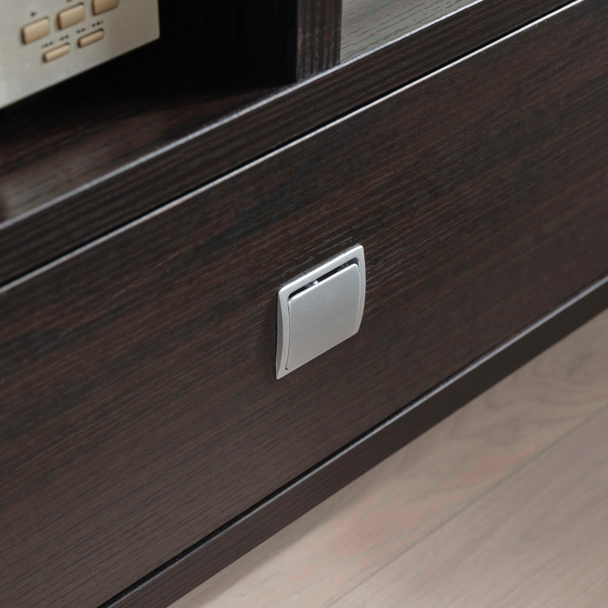 Close-up of drawer handle on modern TV Stand with Storage, showing dark wood finish and sleek silver hardware.