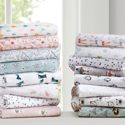 Stacked Twin XL Cotton Flannel Sheet Sets in assorted holiday doodle prints, ideal for cozy dorm bedding and seasonal decor.