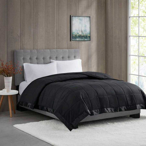 Lightweight Down Alternative Blanket in black twin size on a modern bed with gray headboard, ideal for stylish and cozy bedding upgrades.