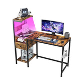 Computer desk with LED lighting and reversible shelves, featuring monitor, keyboard, and organized accessories for home office use.