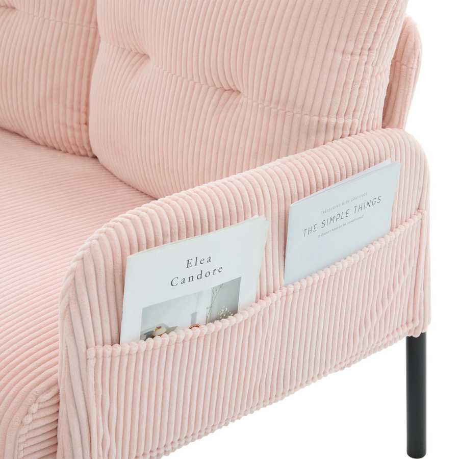 Pink corduroy chair with magazine holder containing books.