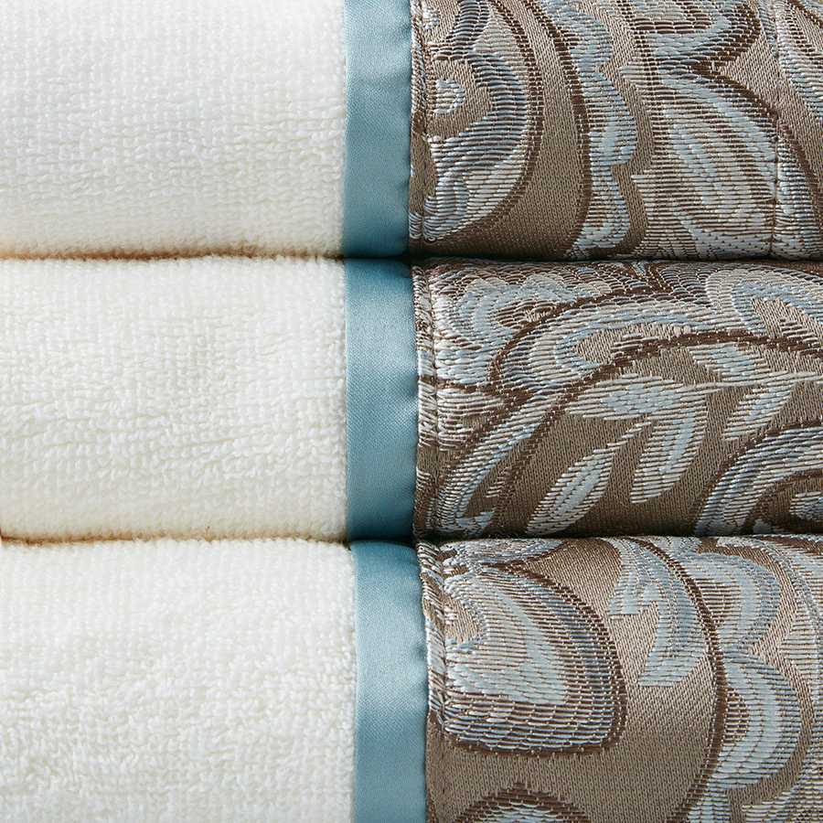 Close-up of Elegant Jacquard Towel Set showing detailed taupe paisley jacquard border and smooth blue satin trim on soft cotton.