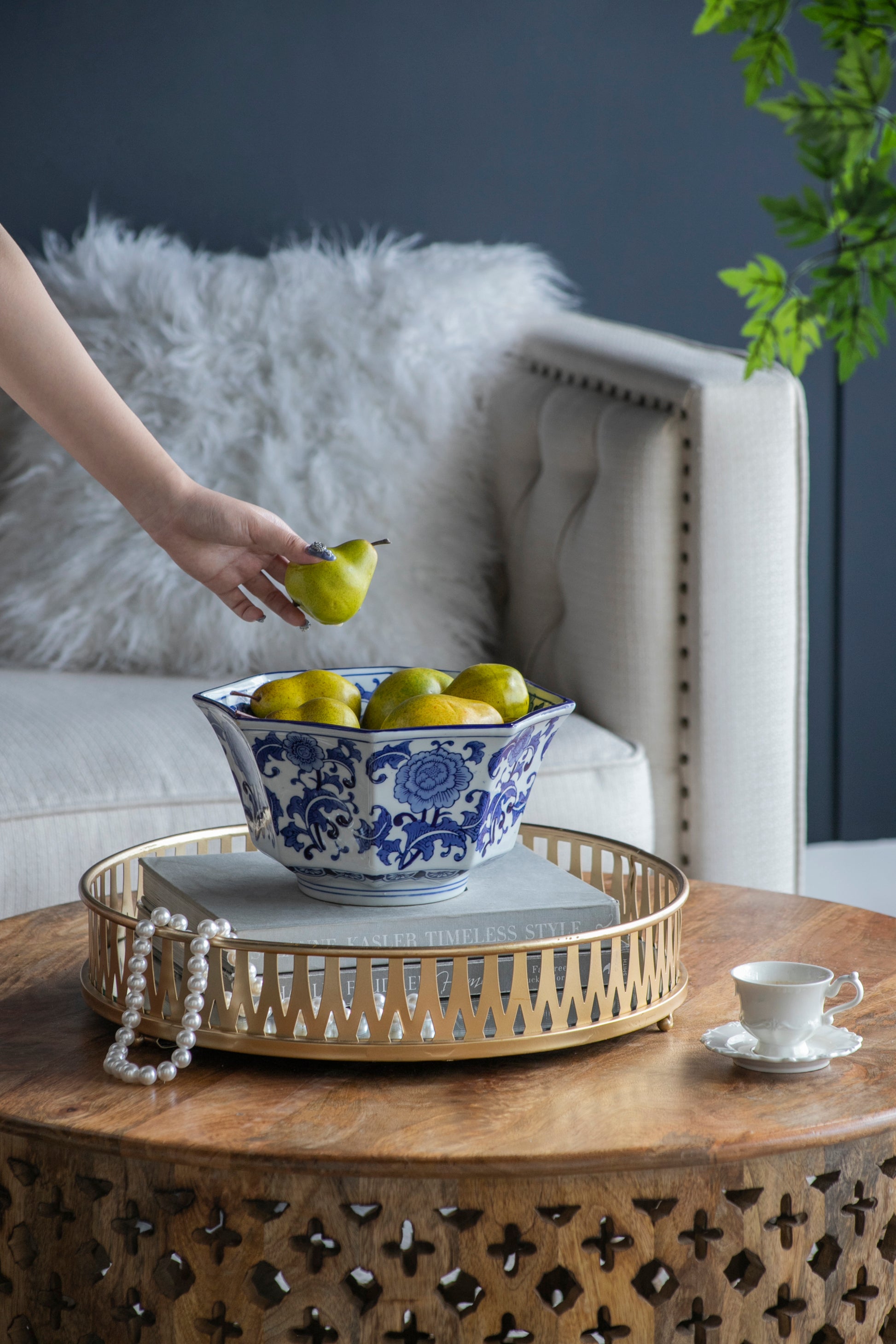 Porcelain Blue and White Decorative Bowl filled with pears, placed on a wooden coffee table in a cozy living room setting.