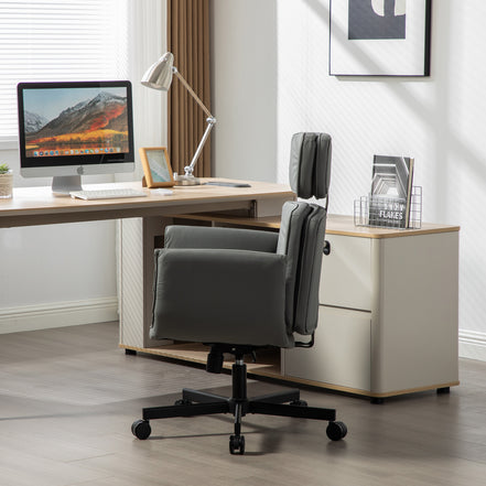Modern office desk with computer, lamp, and gray office chair in a bright room.