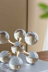 Decorative molecular model with gold and silver elements on a neutral background
