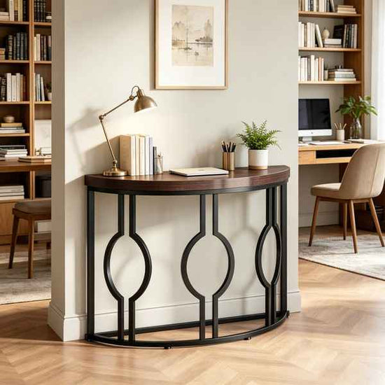 A curved console table with a dark wood top and black metal frame featuring three large interlocking oval motifs, styled in a home office setting.