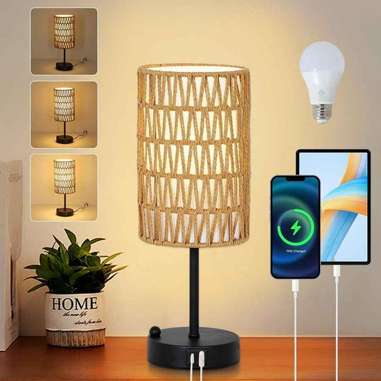 Wicker table lamp on a wooden surface with a plant, smartphone, and tablet in the background.