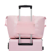 Pink suitcase with a matching pink cover on a white background