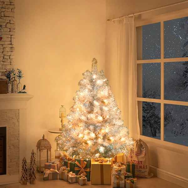 Decorated Christmas tree with lights in a room with a window showing snowy outdoors.