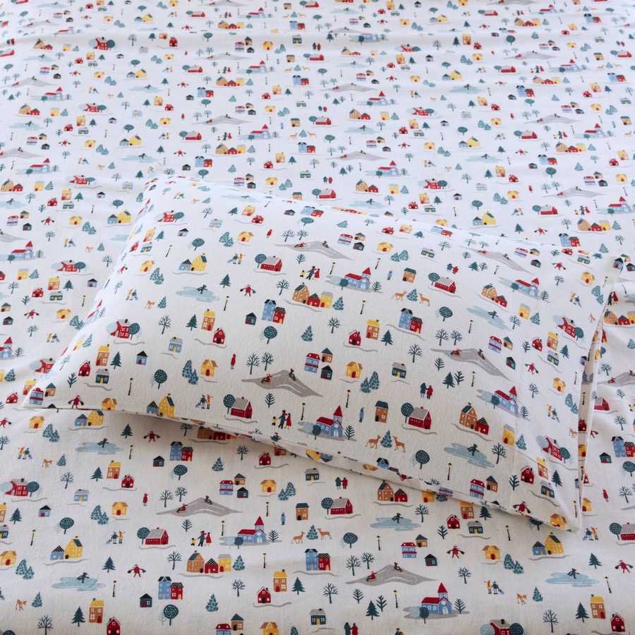 Close-up of 3 PCS Twin XL Printed Sheet Set featuring colorful white village print on flannel fabric, showcasing pillow and sheet detail.