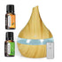 A wooden diffuser with a light blue water band and power button, shown with two small essential oil bottles labeled Hankey Orange and Hankey Mint Leaf, plus a small remote control on a white background.