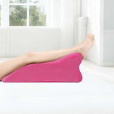 Pink memory foam posture pillow used for leg elevation, enhancing circulation and comfort during rest or recovery.