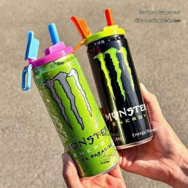 Two Monster Energy drink cans with colorful silicone straw covers, held in hands against a neutral concrete background.