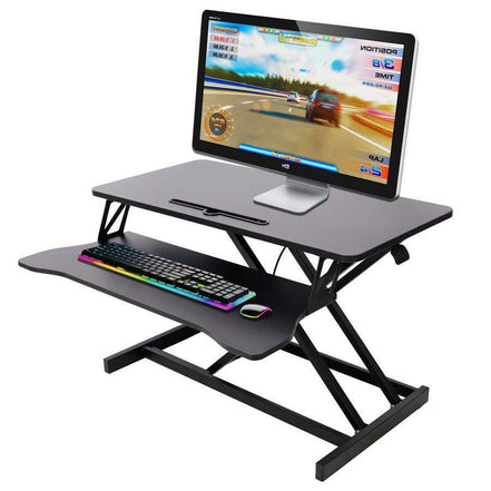 Adjustable height laptop desk with keyboard tray holding a monitor, keyboard, and mouse. Ideal for ergonomic gaming or office setups.
