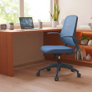 Blue office chair in front of a wooden desk with a laptop and decor items.