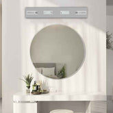 Round mirror on a wall with a light fixture above it in a bathroom setting.
