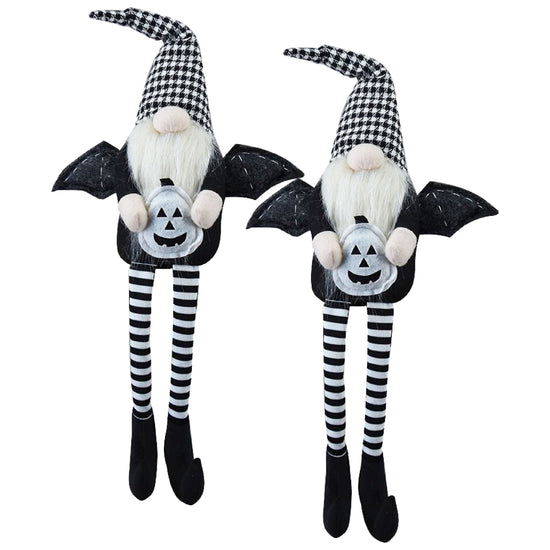 Two Halloween-themed gnomes with bat wings and striped legs on a white background