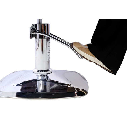 Close-up of foot pedal mechanism on chrome base of salon chair, allowing height adjustment for stylist convenience.