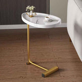 Small round marble table with gold legs in a room setting