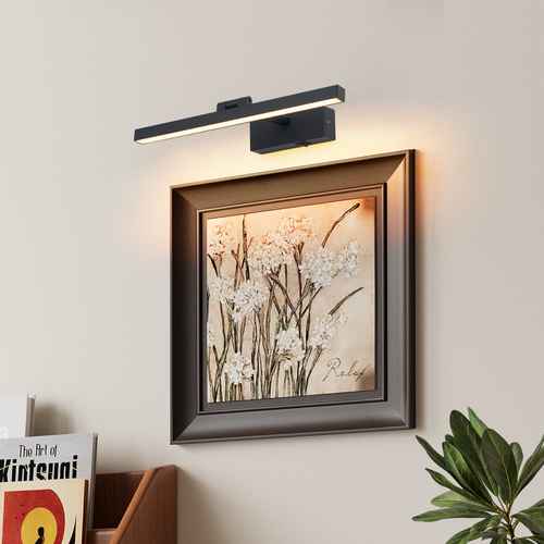 Modern wall light fixture above a framed artwork on a wall.