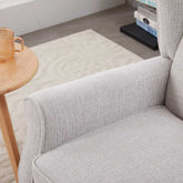 Gray sofa in a living room setting with a wooden side table and books in the background.