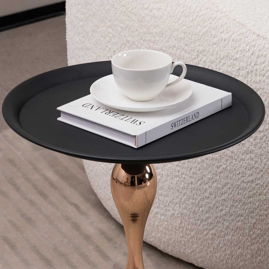 Close-up of the Modern Metal Mermaid Tail Coffee Table top with a cup and book, highlighting its smooth black surface. Perfect for drinks or decor.