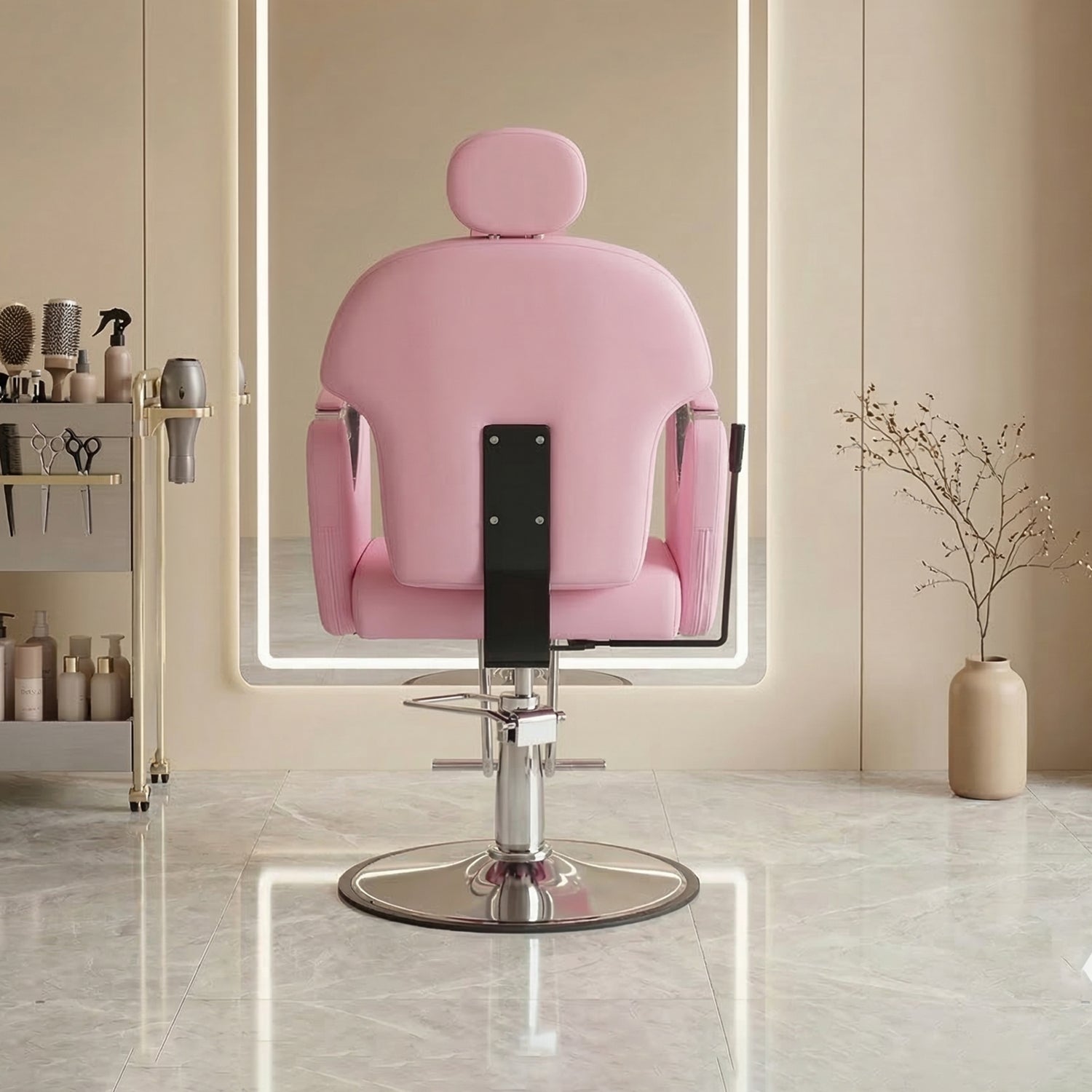 A pink salon chair with a headrest and chrome base, positioned in front of a large backlit mirror in a modern beige salon interior.