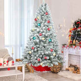 4 ft flocked Christmas tree with pine cones and gifts in a room