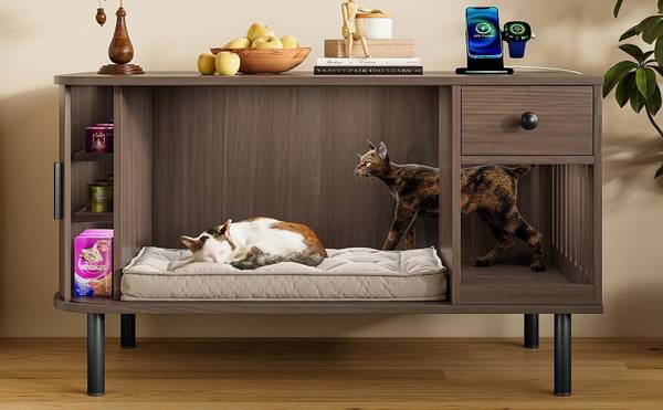 Interior view of cat litter box enclosure with two cats resting on cushion, side storage shelves visible.