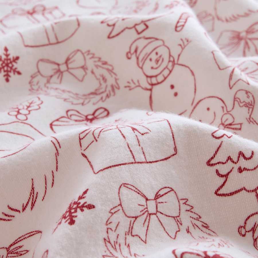 Close-up of soft cotton flannel fabric with red holiday doodles, showcasing the cozy texture of the Twin XL sheet set.