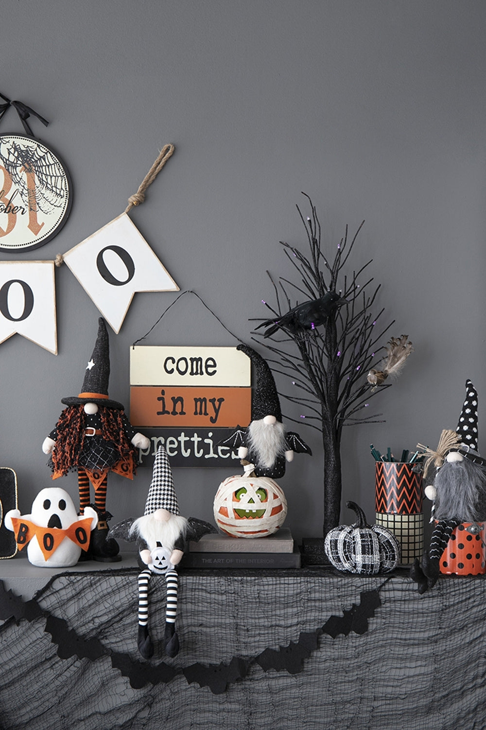Halloween-themed decorations on a shelf against a gray wall.