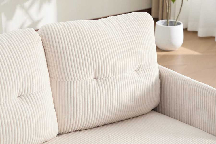 Close-up of a beige textured sofa with cushions in a room setting.