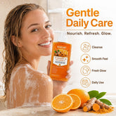 A smiling woman in a shower holds a box of BARUBT Turmeric & Vitamin C Gentle Daily Care exfoliating body wash. The image features promotional text on the right detailing benefits like &