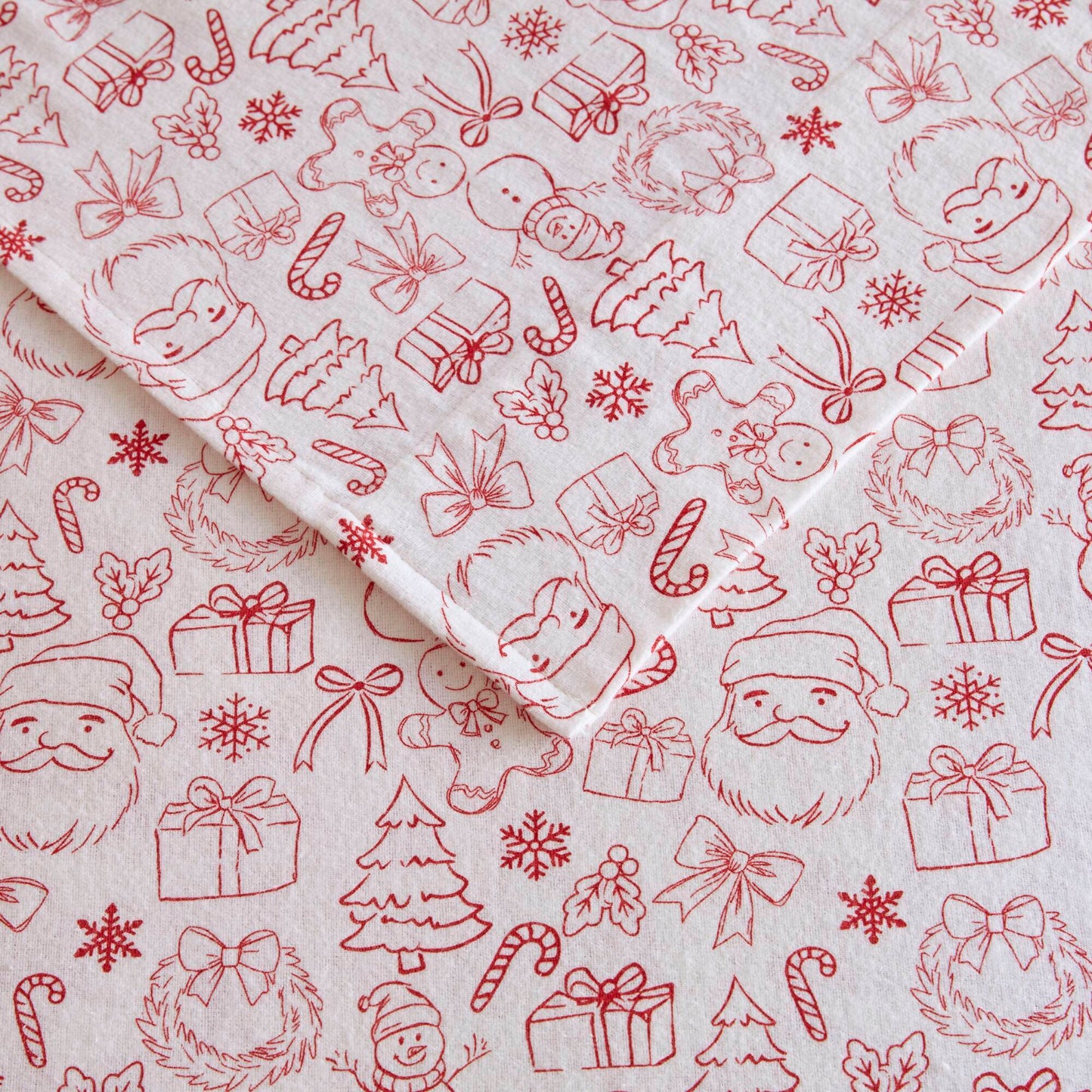 Detailed view of Twin XL Cotton Flannel Sheet Set with red holiday doodles including Santa, gifts, and snowflakes on soft fabric.