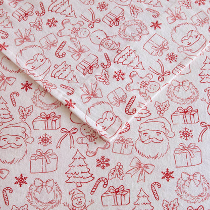 Detailed view of Twin XL Cotton Flannel Sheet Set with red holiday doodles including Santa, gifts, and snowflakes on soft fabric.