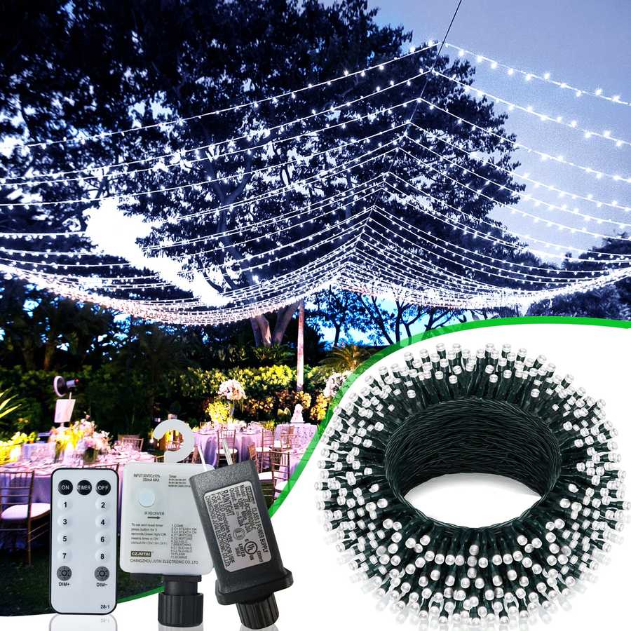 String lights with remote control and power adapter, set up outdoors with trees and tables in the background.