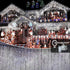 House roofline decorated with cold white 1000 LED icicle curtain fairy lights