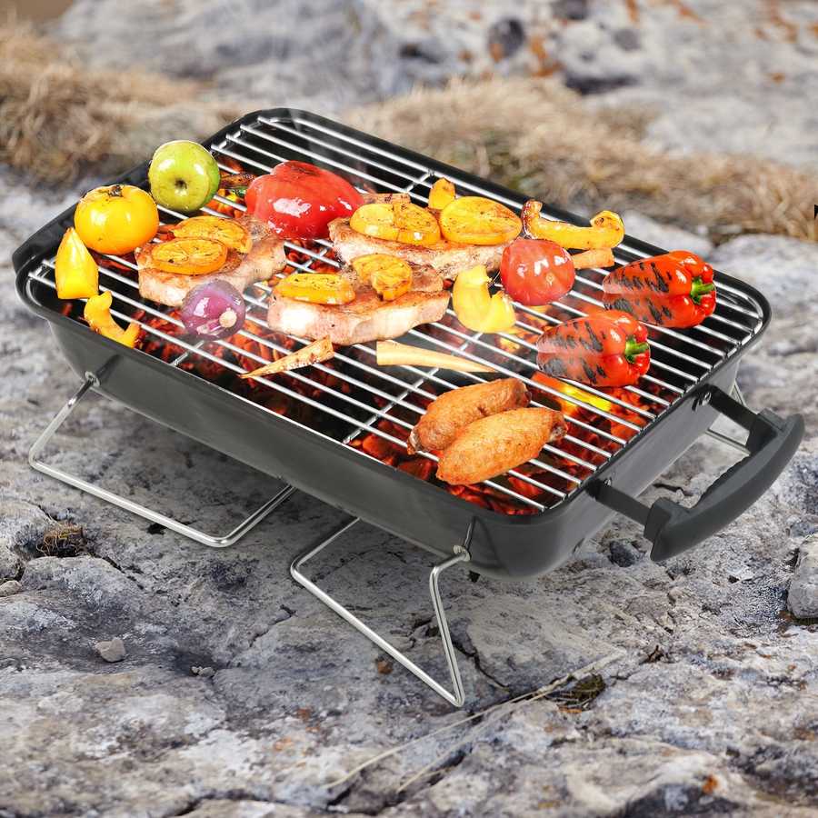 Portable grill with food on a rocky surface