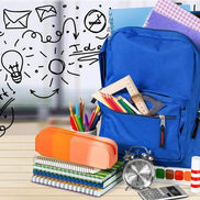 Blue backpack with school supplies including notebooks, pens, and a clock on a wooden surface.