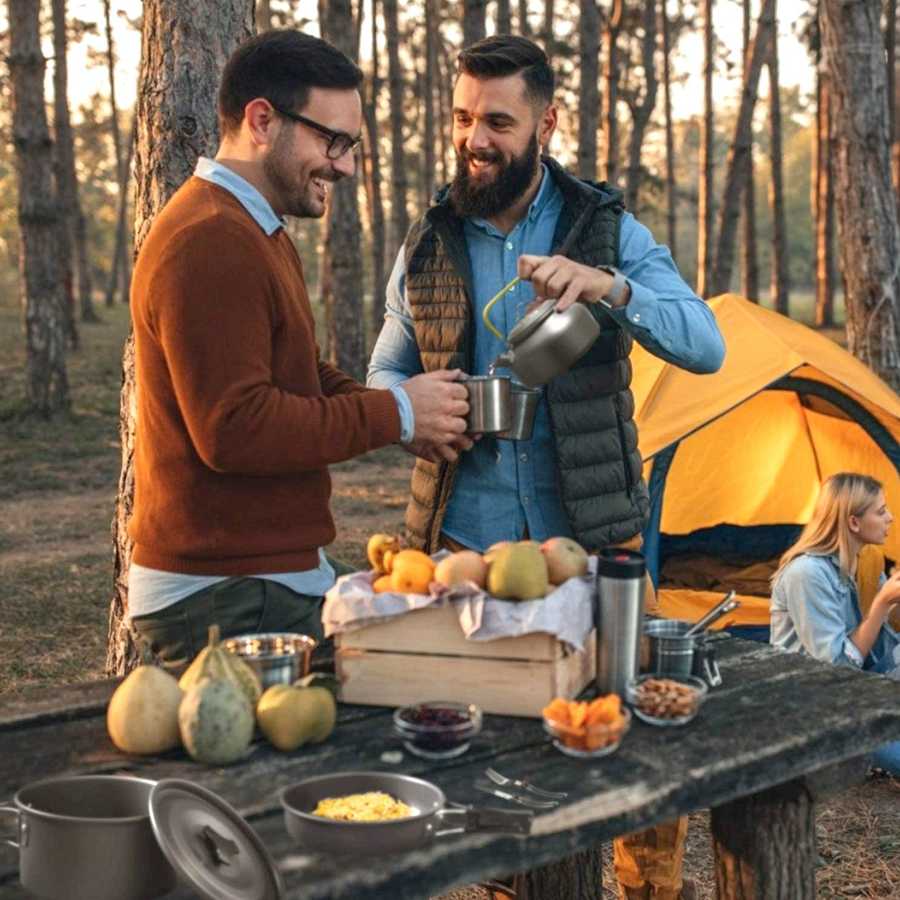 Campers using 12Pcs Camping Cookware Set while enjoying a meal outdoors. Ideal for group camping and outdoor adventures.